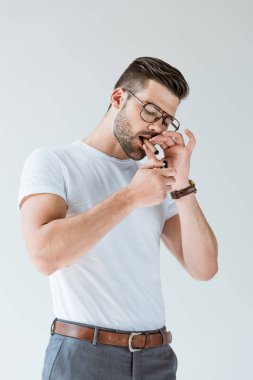 Moda kendine güvenen adam beyaz arka plan üzerinde izole onun puro aydınlatma