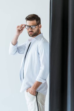 Kendine güvenen genç adam gözlüklü siyah perde ile ayakta