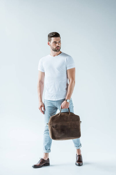 Stylish young man carrying briefcase on white background