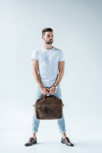 Handsome bearded man carrying briefcase on white background