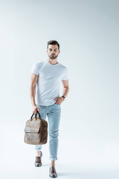 Fashionable confident man carrying briefcase on white background