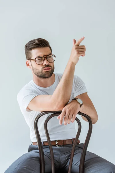 Bello Uomo Barbuto Seduto Sulla Sedia Fingendo Sparare Isolato Sfondo — Foto stock gratuita