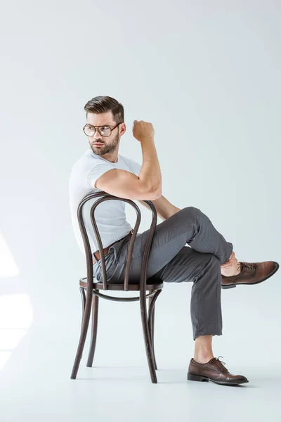 Jovem Elegante Óculos Sentado Cadeira Fundo Branco — Fotografia de Stock