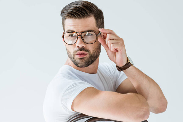 Fashionable confident man fixing his glasses isolated on white background