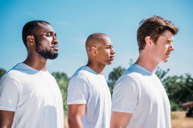 yaz gününde aralığı üzerinde duran Interracial genç askerleri yan görünüm