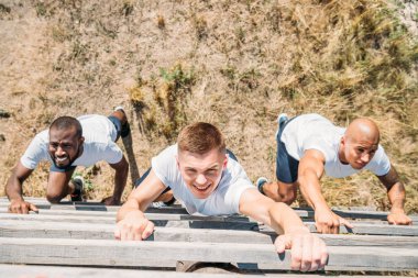 overhead view of multiethnic soldiers practicing in obstacle run on range clipart