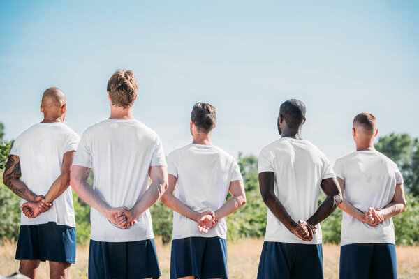 вид на многорасовых солдат, стоящих на стрельбище в летний день
