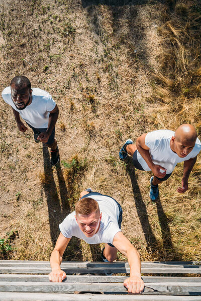 overhead view of multiethnic soldiers practicing in obstacle run on range