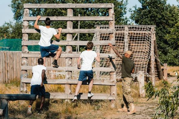 Instruktora Taktycznego Badając Wielorasowe Żołnierzy Podczas Przeszkody Zakres — Zdjęcie stockowe