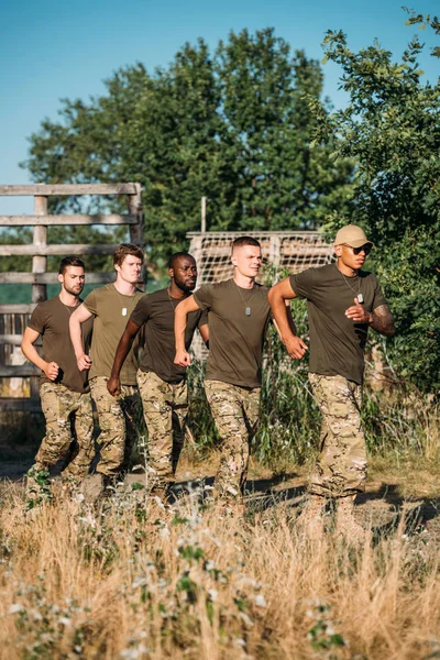 multiethnic soldiers in military uniform running on range