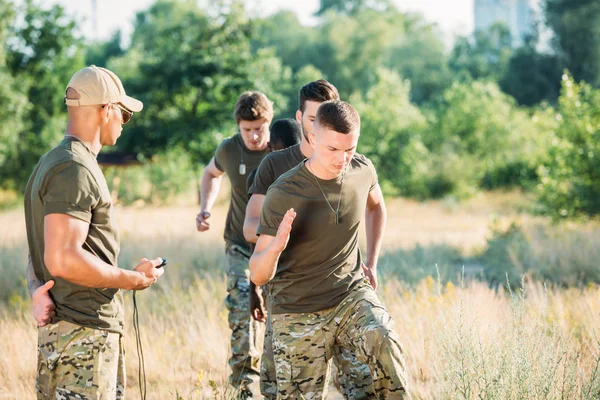 Instructeur Tactique Avec Chronomètre Examinant Les Soldats Multiraciaux Pendant Course — Photo