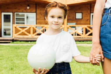 sevimli küçük çocuk anneler elini tutarak voleybol topu ile