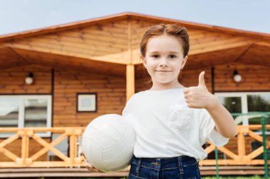 başparmak gösterilmesini ve kameraya bakarak voleybol topu ile sevimli küçük çocuk