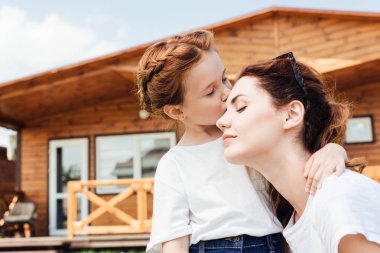 mutlu anne ve kızı önünde Ahşap yazlık sarılma