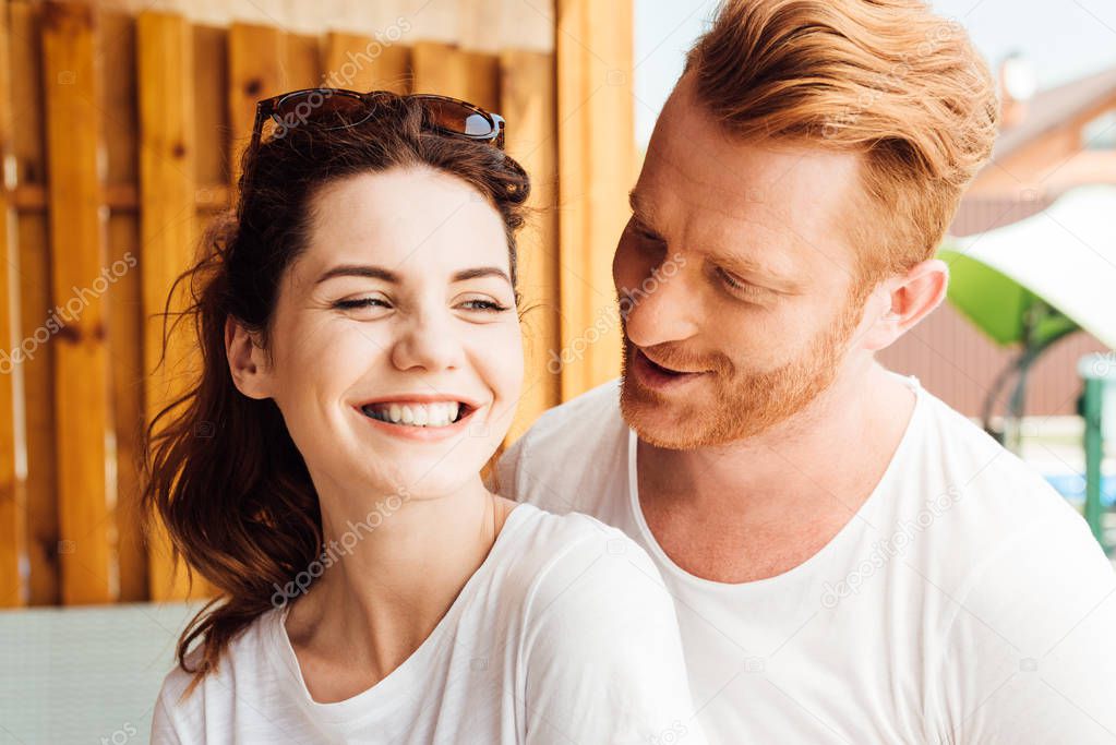 close-up portrait of young cuddling couple in white t-shirts