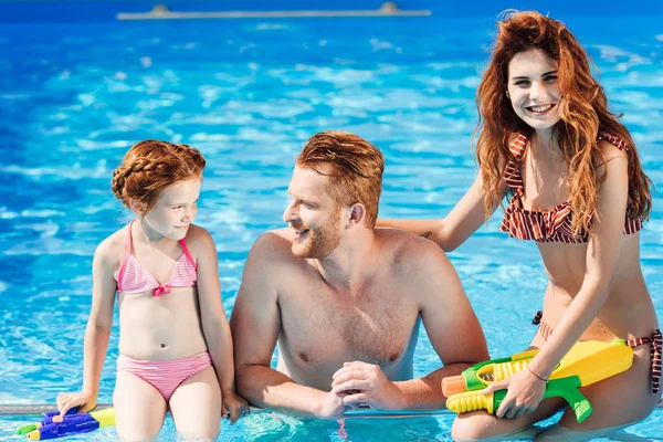 美丽的年轻家庭花时间在游泳池 — 图库照片