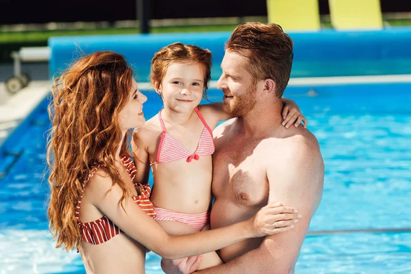 美丽的年轻家庭拥抱在游泳池里 — 图库照片