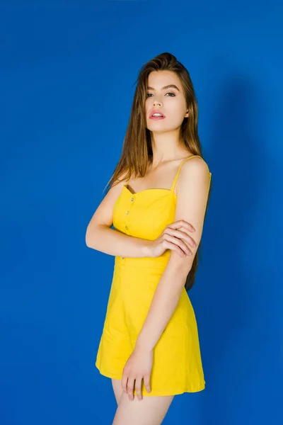 Elegancka Brunetka Kobieta Żółtej Sukience Pozowanie Niebieskim Tle — Zdjęcie stockowe