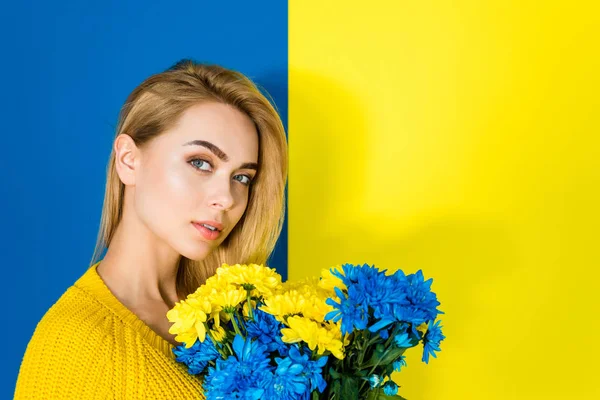 Schöne Blonde Mädchen Mit Chrysanthemenblüten Auf Blauem Und Gelbem Hintergrund — Stockfoto