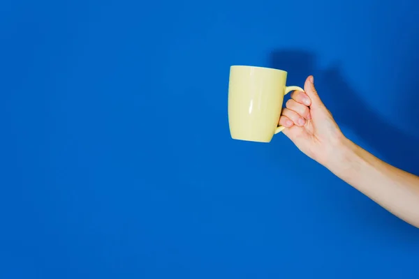 Cropped View Female Hand Yellow Cup Blue Background — Stock Photo, Image