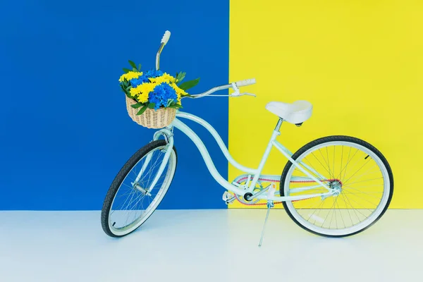 Vrouwelijke Fiets Met Bloemen Mand Blauwe Gele Achtergrond — Stockfoto