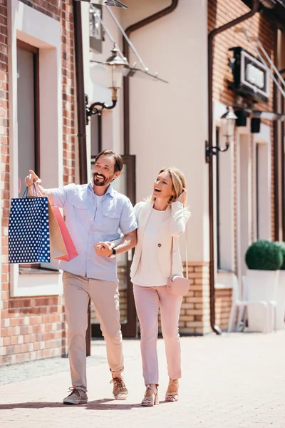 Homem Carregando Sacos Compras Apontando Algo Para Mulher Rua — Fotografia de Stock