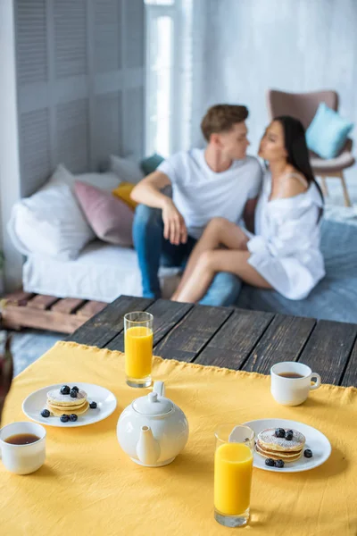 朝食はテーブル 寝室のベッドの上に座って愛の異人種間のカップルの選択と集中  — 無料ストックフォト
