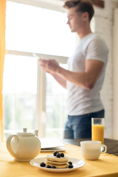 Seçici Odak Kahvaltı Masa Evde Akıllı Telefon Kullanan Adam — Ücretsiz Stok Fotoğraf