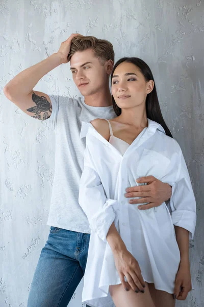 Retrato Caucaisan Homem Abraçando Asiático Namorada Branco Camisa Casa — Fotografia de Stock