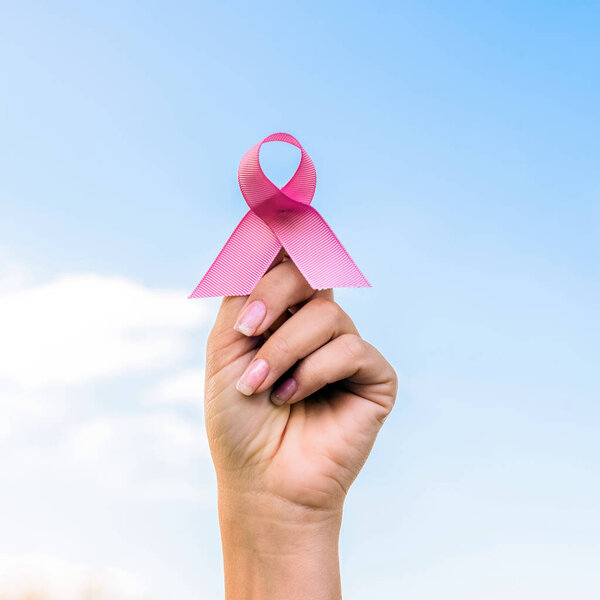 cropped shot of woman holding breast cancer awareness ribbon