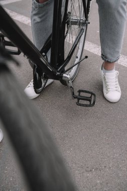 kot pantolon ve spor ayakkabı bisiklet üzerinde oturan kadın bacak resim kırpılmış 