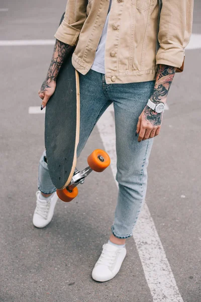 Cropped Image Stylish Tattooed Woman Holding Skateboard Parking Lot — Free Stock Photo