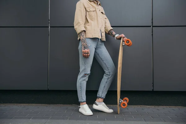 Visão Parcial Mulher Tatuada Elegante Com Skate Contra Parede Preta — Fotografia de Stock