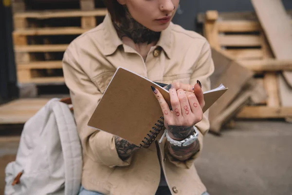 Περικομμένη Εικόνα Τατουάζ Γυναίκα Γράφοντας Στο Βιβλίο — Φωτογραφία Αρχείου