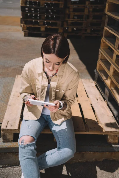 Hochwinkel Ansicht Tätowierter Frau Mit Digitalem Tablet Sitzen Auf Palette — kostenloses Stockfoto