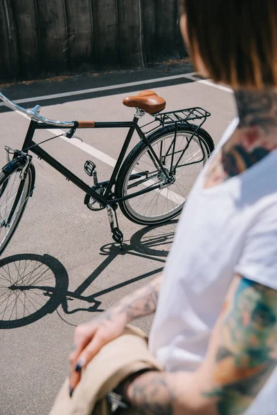 Μερική Άποψη Του Τατουάζ Γυναίκα Στέκεται Κοντά Ποδηλάτων Στην Οδό — Δωρεάν Φωτογραφία
