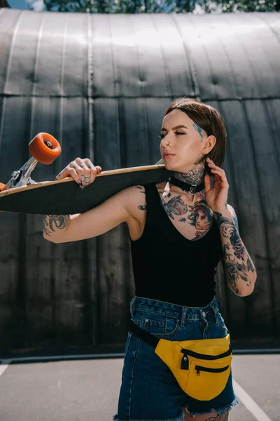 Young Stylish Tattooed Girl Looking Away Holding Skateboard Shoulder — Stock Photo, Image