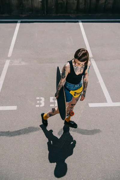 Μεγάλη Γωνία Θέα Κομψό Κορίτσι Τατουάζ Κρατώντας Skateboard Στο Πάρκινγκ — Φωτογραφία Αρχείου