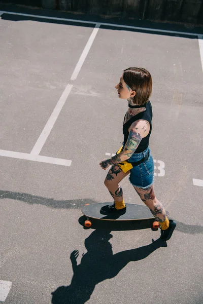 Overhead View Stylish Tattooed Girl Skateboarding Parking Lot — Free Stock Photo