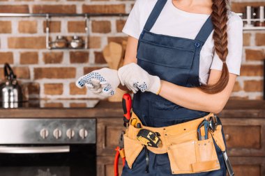 cropped shot of repairwoman putting on work gloves clipart