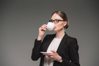 gri arka plan üzerinde izole fincan kahve içme gözlük işkadını 