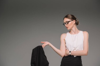 çekici işkadını uzağa bakarak ve ceket gri arka plan üzerinde izole tutan gözlük yan görünüm 