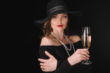 elegant attractive woman in black straw holding champagne glass isolated on black background  clipart