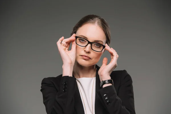 Atrakcyjna Kobieta Interesu Dostosowanie Okularów Patrząc Kamery Białym Tle Szarym — Zdjęcie stockowe