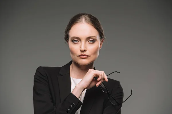 Businesswoman Holding Eyeglasses Looking Camera Isolated Grey Background — Stock Photo, Image