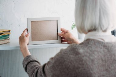 evde boş fotoğraf çerçevelemek--dan bookshelf alarak üst düzey Bayan kısmi görünümünü