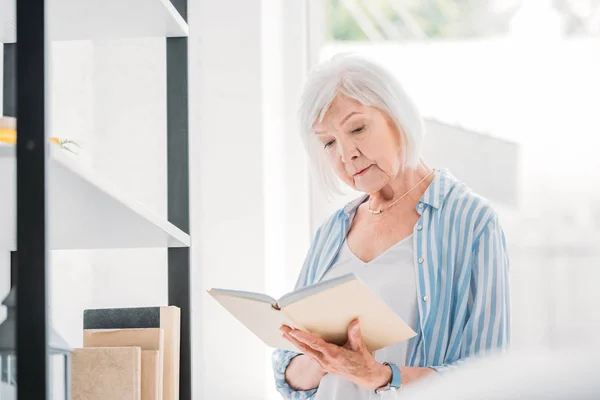 Portrait Grey Hair Woman Reading Book Bookshelf Home — Stock Photo, Image