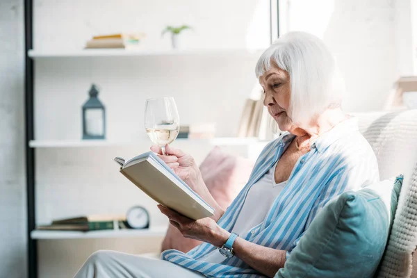 Vista Lateral Mulher Sênior Focada Com Copo Vinho Livro Leitura — Fotografia de Stock