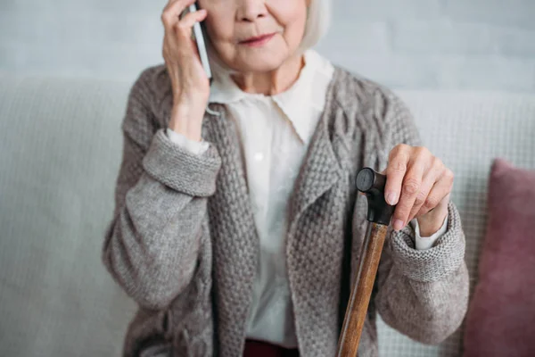 Teilbild Einer Seniorin Mit Gehstock Die Hause Auf Dem Smartphone — kostenloses Stockfoto