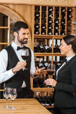couple of wine stewards making degustation together and chatting at wine store clipart